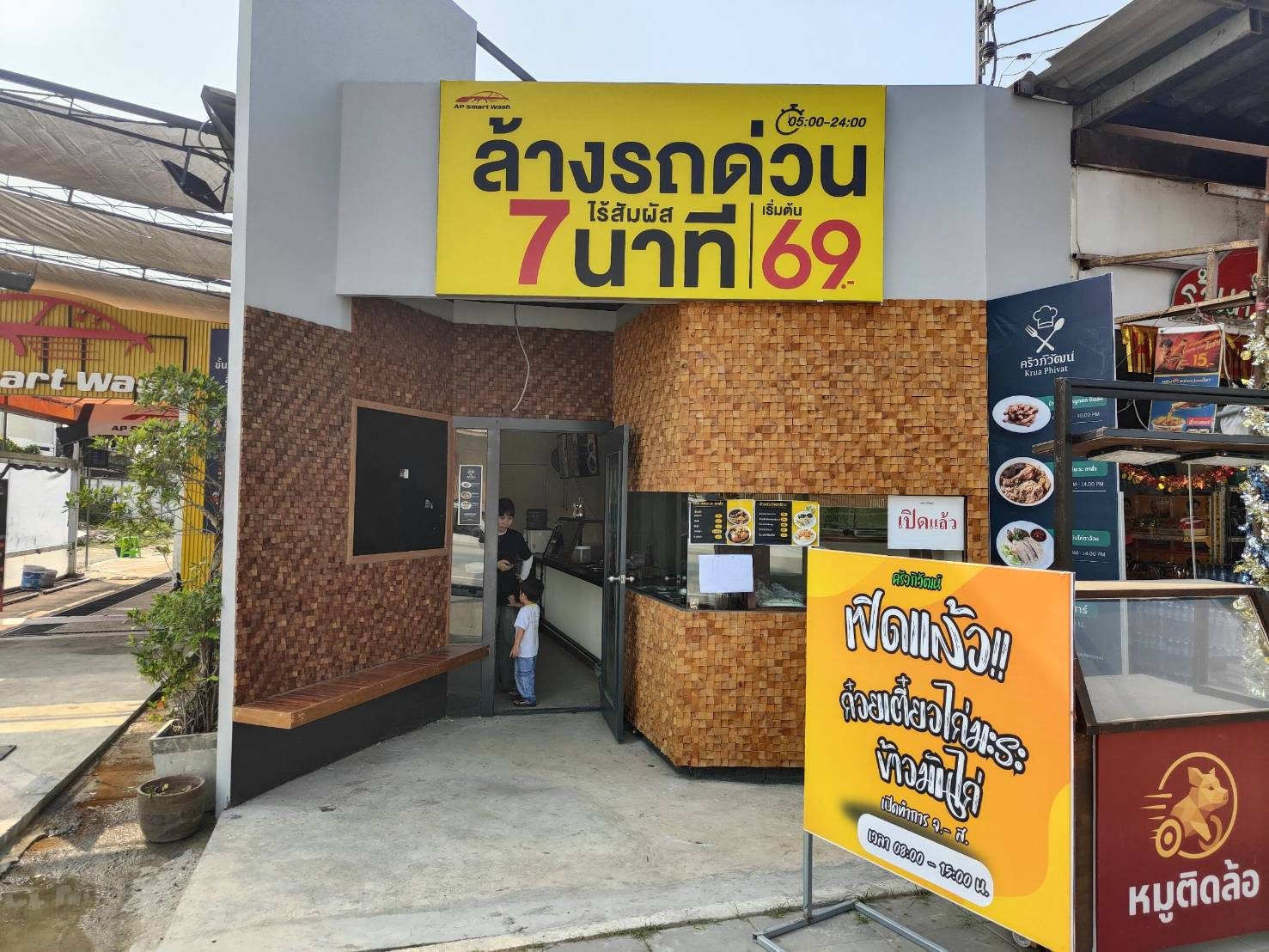 มุมเฉียงอาคารหน้าร้าน AP Smart Wash งานผนังไม้และป้ายหน้าร้าน