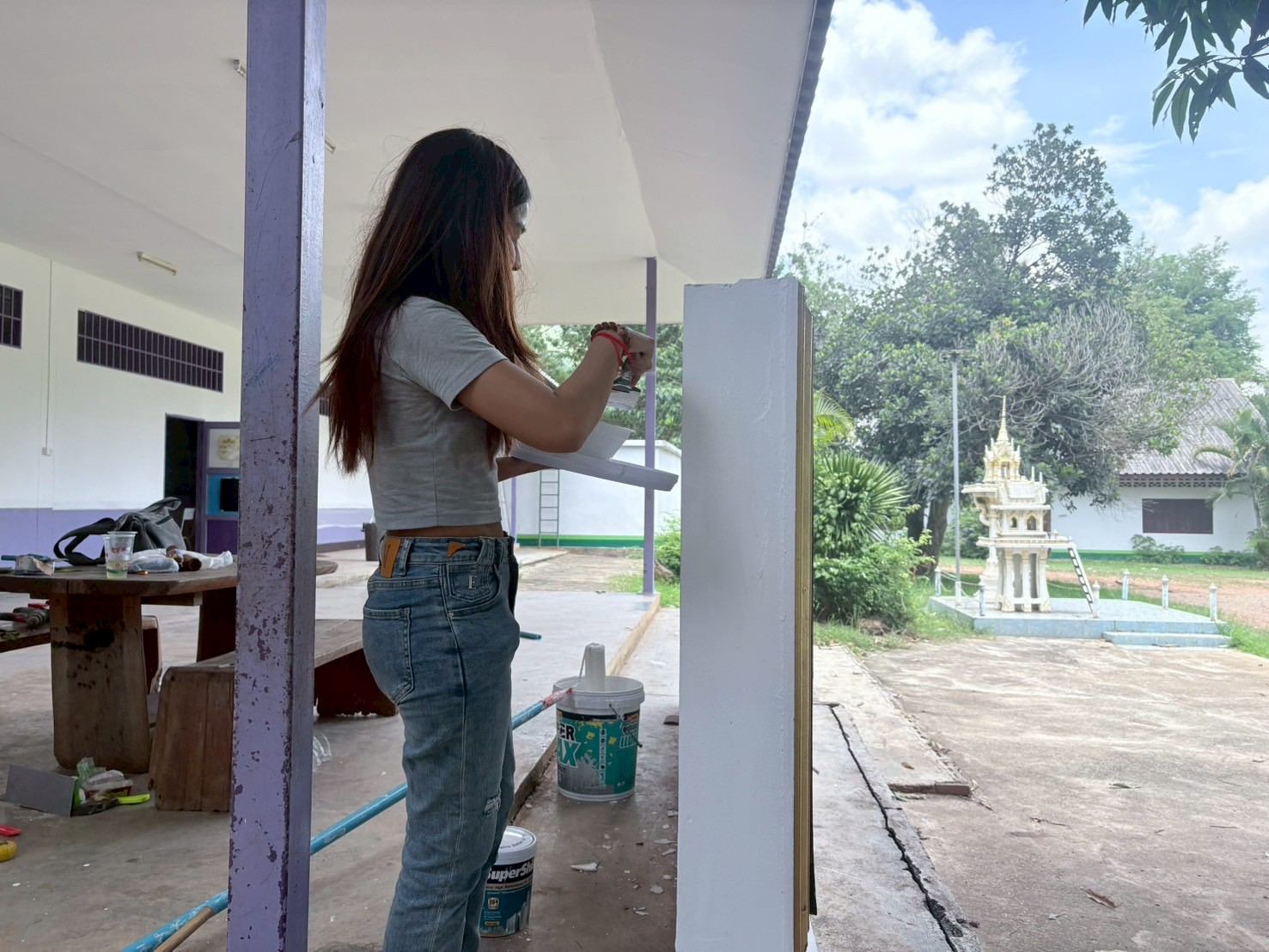 อาสาสมัครทาสีเสาระเบียงอาคารเรียน