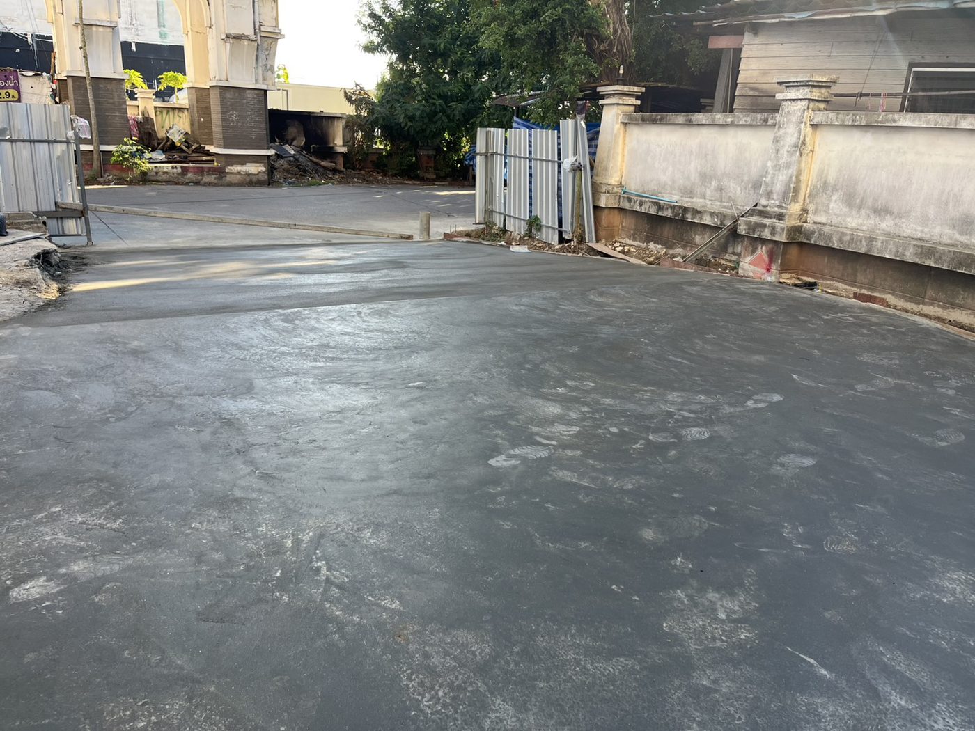 พื้นคอนกรีตลานล้างรถสดใหม่เรียบ ด้านหลังอาคาร — APW Aphiwat Building